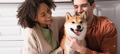 Smiling couple holding a dog
